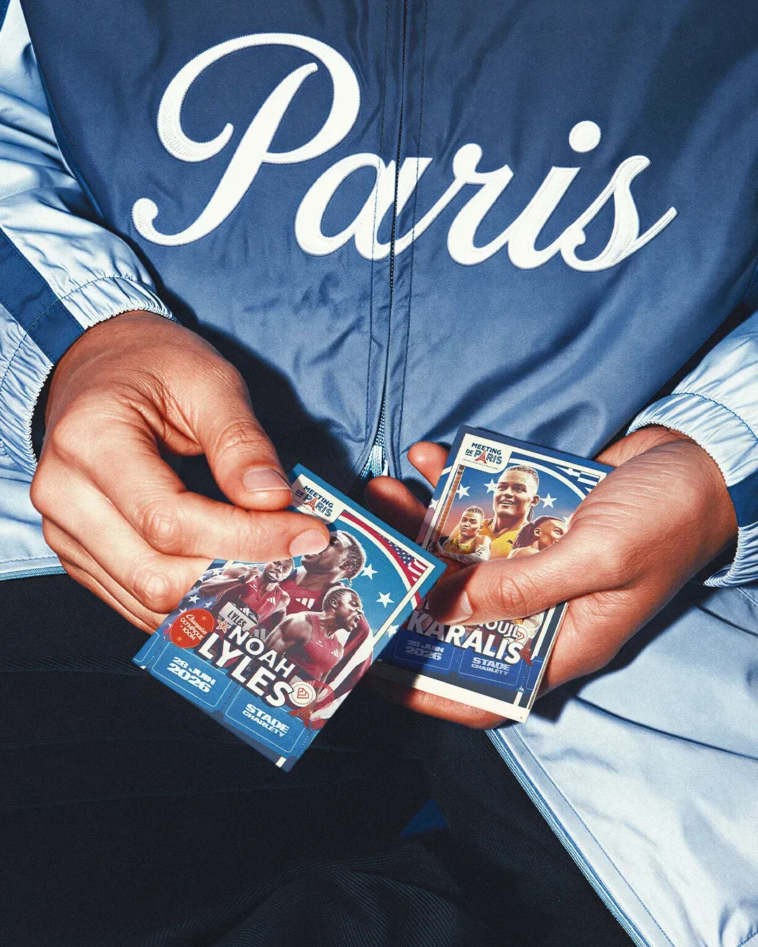 Mains tenant des pochettes de cartes du Meeting de Paris, lettrage Paris manuscrit