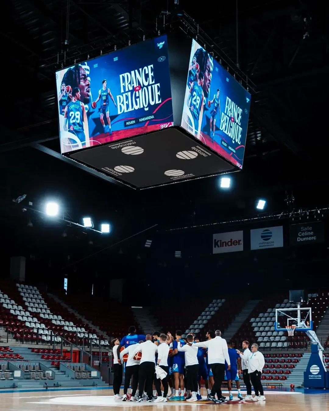 Équipe de France de basket alignée sur le parquet avant le match, habillage LED de la salle