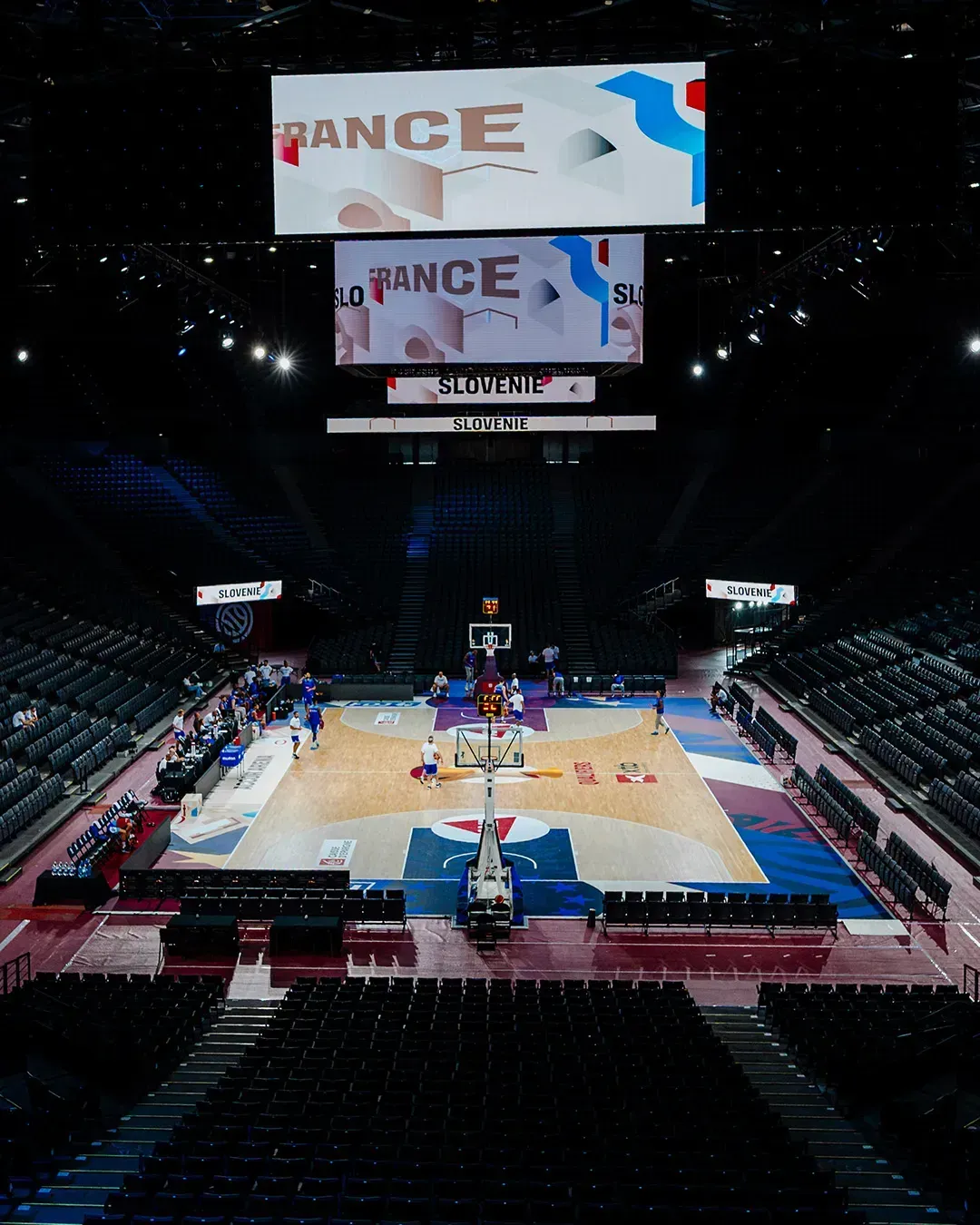 Vue de face du parquet habillé aux couleurs de la FFBB dans une salle vide
